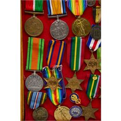 Twenty three WWI and WWII medals and miniatures, including The Defence medal, two of  The Pacific Star, The Burma Star, Efficient Service medal, American Campaign etc, all within a framed display H31cm, W31cm 