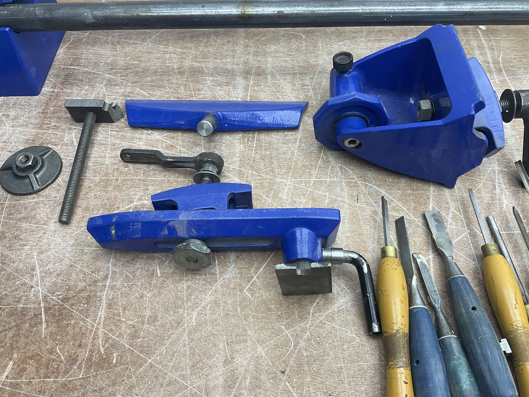 Record wood turning lathe and motor, with a three jaw chuck, tailstock and tool rest, selection of wood turning and woodworking chisels, electric bench grinder with grinding wheel and collet chuck plus a Record bench vice.