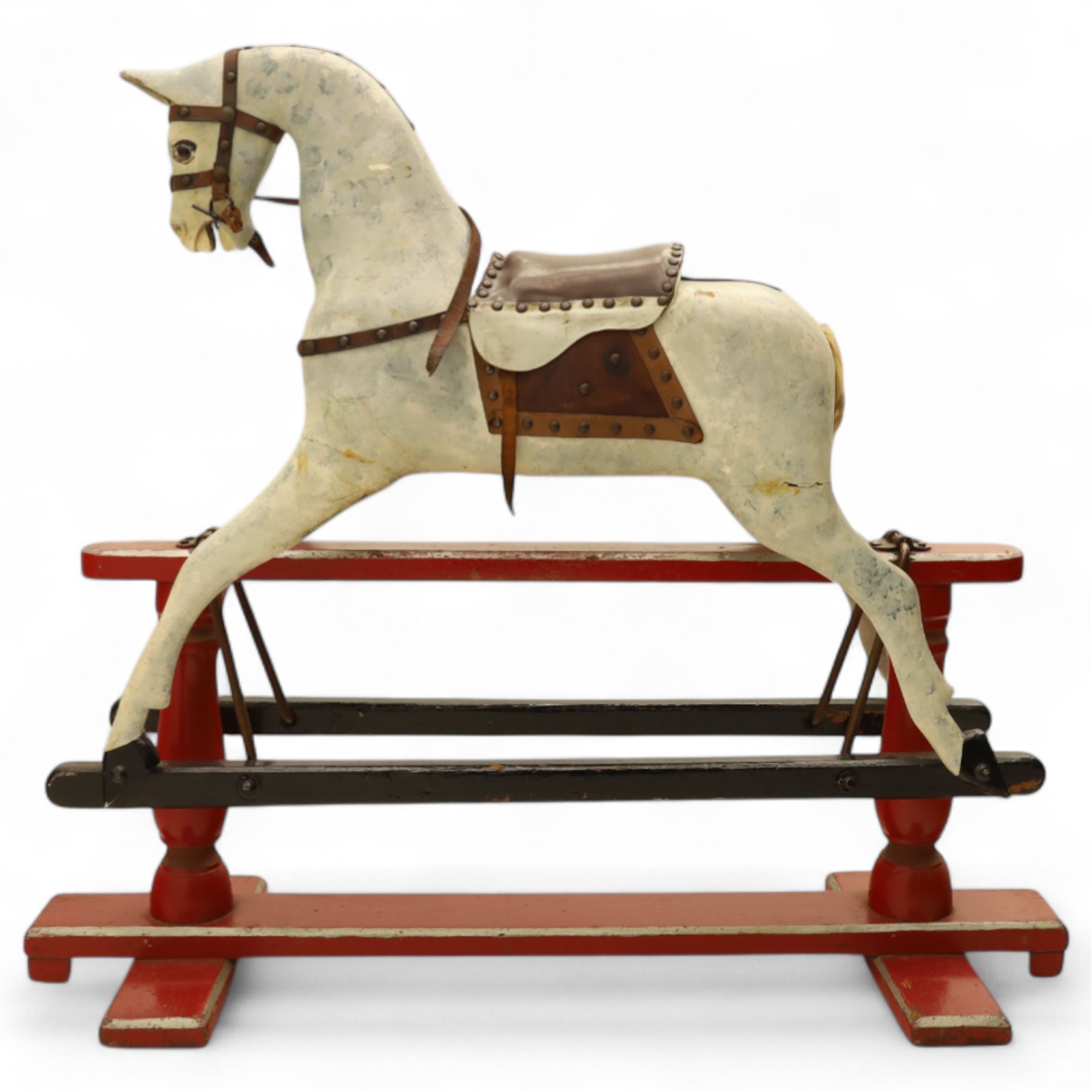 20th century carved and painted rocking horse, with original dappled paint finish, studded leather saddle and reins, on later red and black swing frame