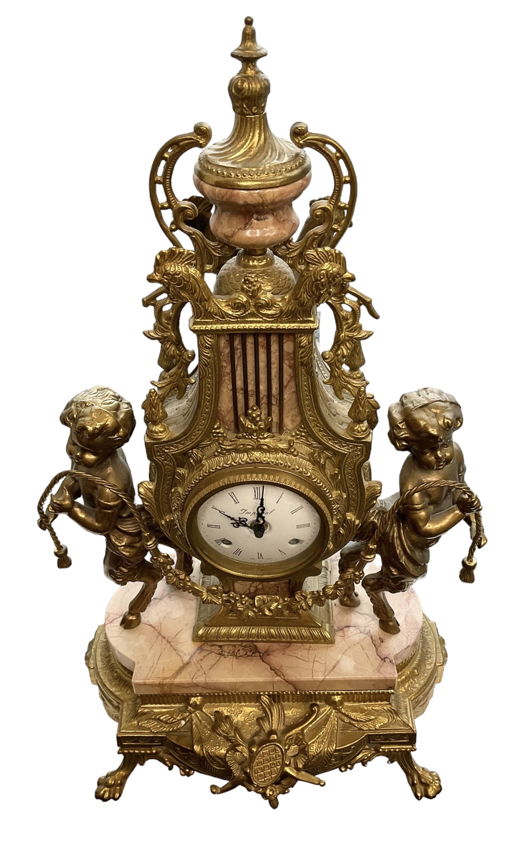Imperial - 20th century continental 8-day brass and marble mantle clock, with an enamel dial, Roman numerals and pierced gilt hands, twin train striking movement sounding the hours and half hours on two bells, with a floating balance escapement.  With key.