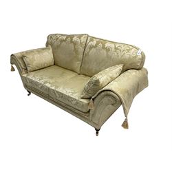 Steed Upholstery - two seat traditional shaped sofa, upholstered in cream fabric with scrolling foliate pattern, on turned front feet with brass castors, with side cushions and arm covers
