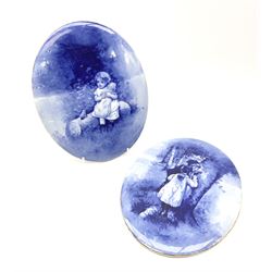 A pair of Royal Doulton blue and white plaques, of oval form decorated with children, one example with printed mark beneath, H24.5cm L19.5cm. 