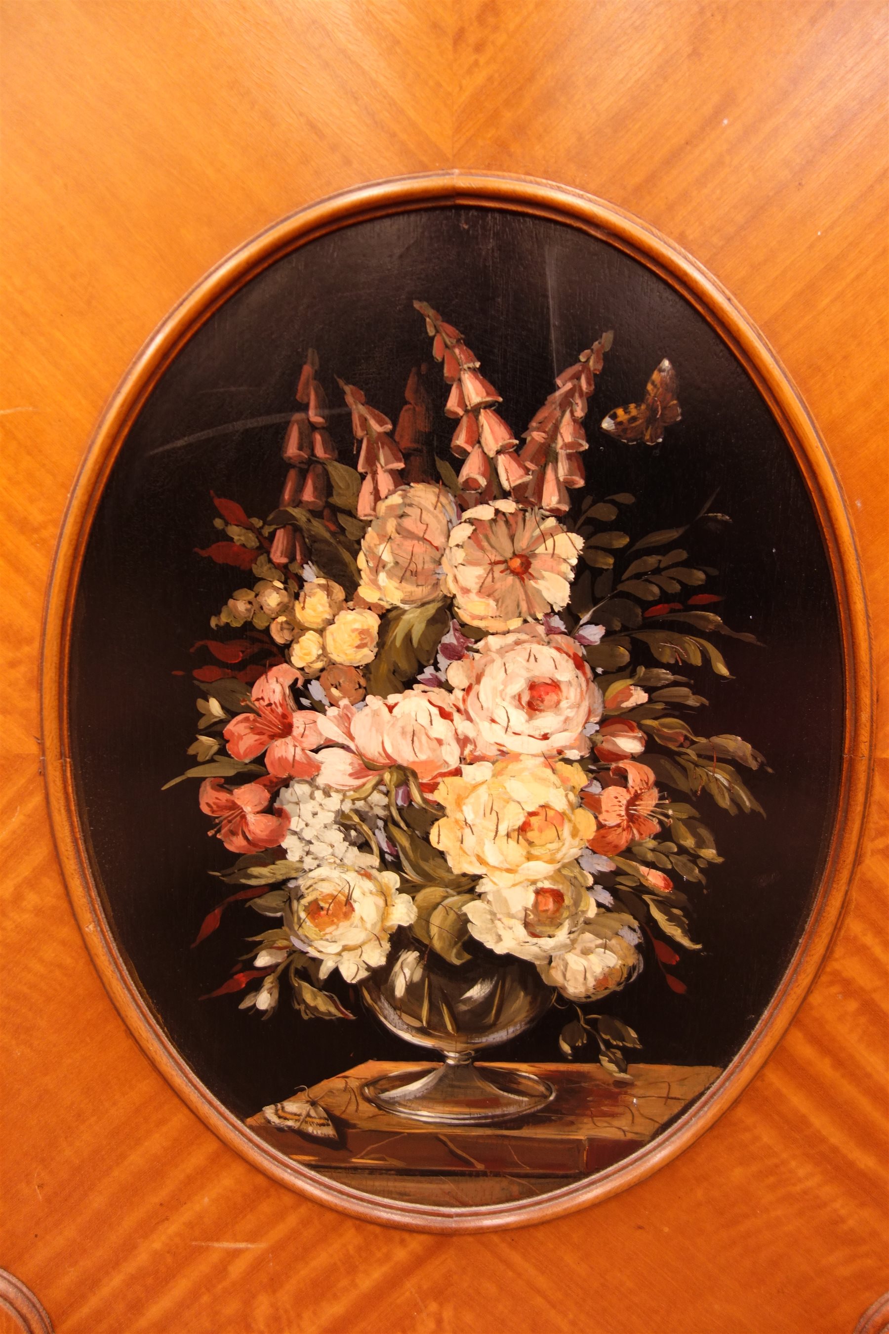 Sheraton Revival satinwood breakfront bookcase, frieze painted with scrolling leafage above four astragal doors with adjustable shelves, the base with four doors painted with floral sprays in oval panels, on a plinth base, W234cm, H235cm, D52cm