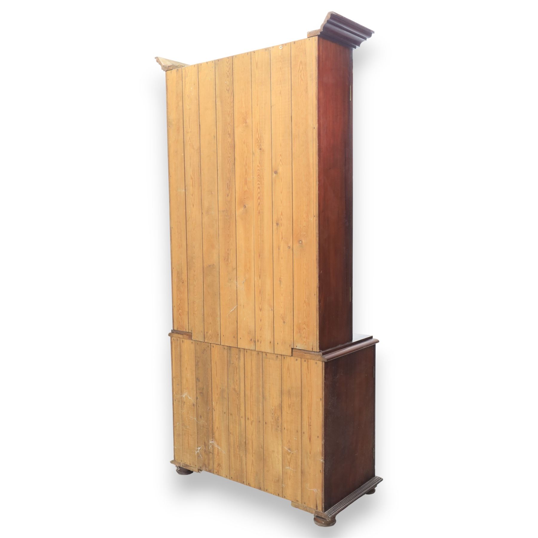 20th century mahogany display bookcase, projecting moulded cornice over a pair of glazed doors with shaped upper glazing and plain lower panes, opening to reveal shelved interior, the base with two recessed panel cupboard doors, raised on a moulded plinth with compressed bun feet