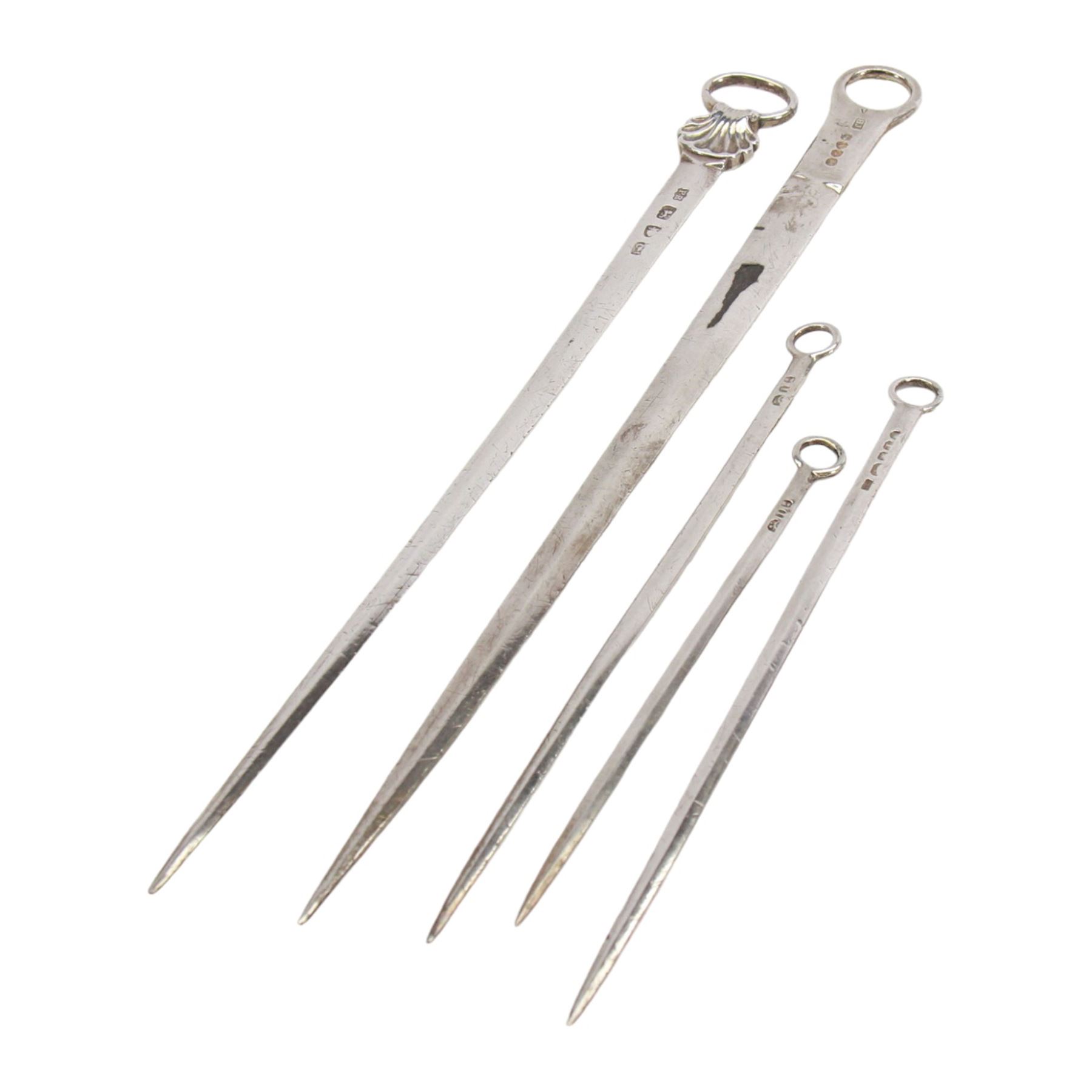 Two George III silver meat skewers, the first example with shell mounted ring terminal, hallmarked Philip Roker III, London 1765, L31cm, the second with ring terminal, hallmarked Thomas Wilkes Barker, London 1810, L32.5cm, together with three George III silver poultry skewers, one example hallmarked Solomon Hougham, London, date letter worn, possibly 1804/1806, and two hallmarked London 1804, no visible makers marks, longest poultry skewer L20cm, smallest L15.5cm, bearing Christie's lot label, (5)

Provenance: Lot 225, portrait Miniatures, Objects of Vertu and Silver, Christie's, 22nd February 2005