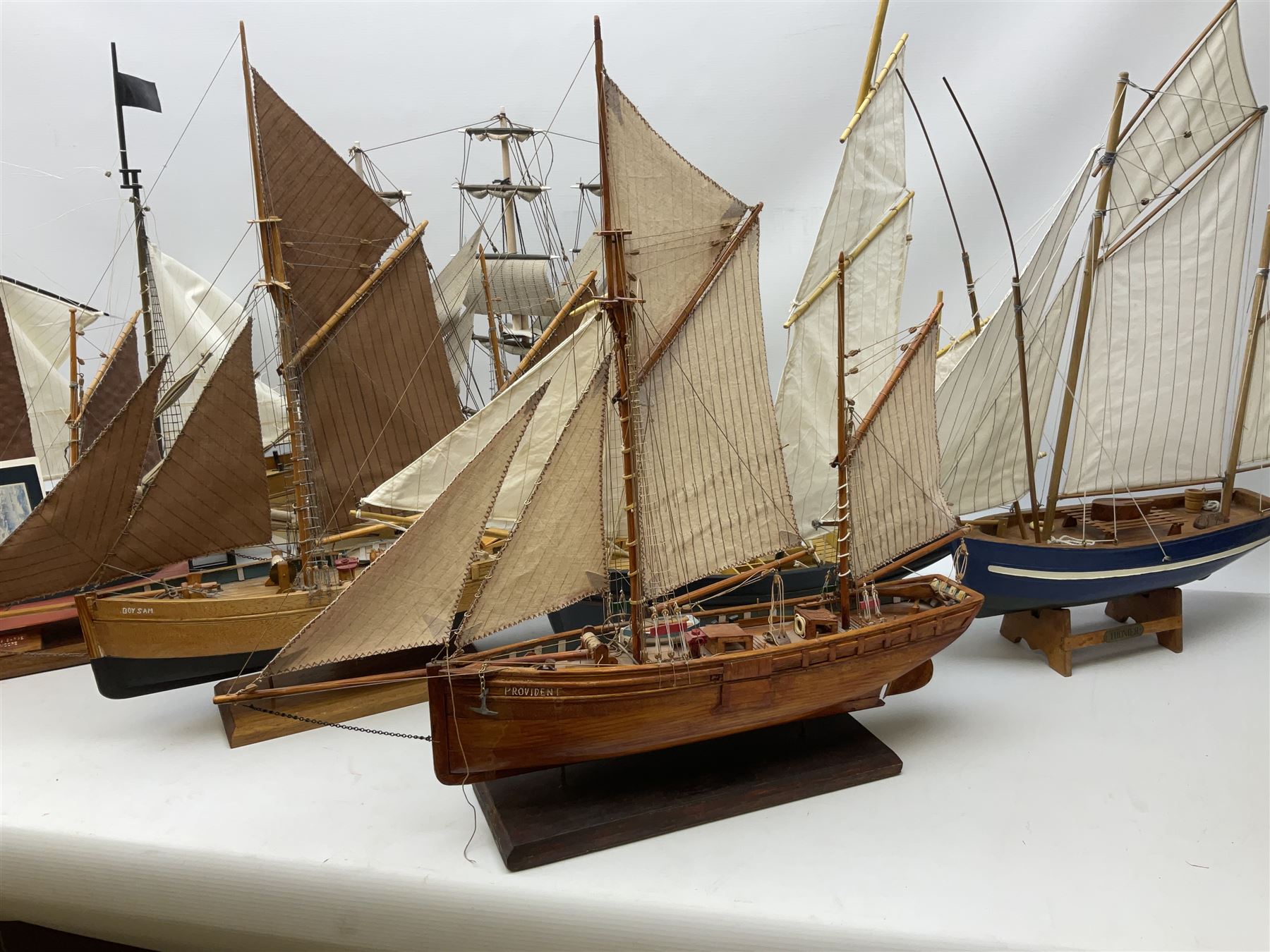 Eight model ships or boats including fishing boat with fish, nets and buoyancy aid, two mast sailing ship complete with cannons, two mast yacht with detailed rigging and life boat etc, the largest L72cm, H60cm