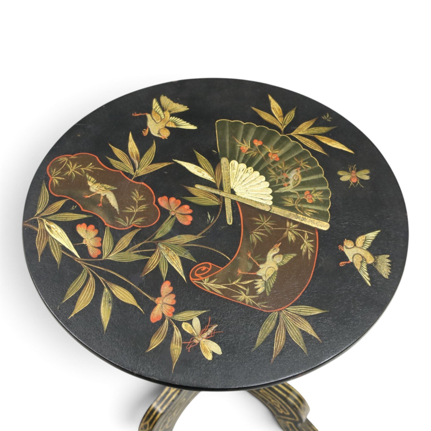 Late Victorian Aesthetic Movement ebonised and parcel-gilt lacquered occasional table, the circular tilt-top decorated in the Anglo-Japanese taste with motifs of fans, birds, insects and flowering branches, raised on a turned pedestal and tripod base shaped splayed supports