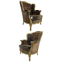 Pair of Louis XVI design gilt framed wingback armchairs, cresting rail carved and moulded with foliate decoration and C-scrolls, upholstered in buttoned floral patterned mauve velvet with loose seat cushion, scallop carved apron over cabriole supports