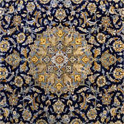 Central Persian Kashan hand-knotted rug, deep indigo field with central floral medallion surrounded by an all-over arrangement of palmettes, flowering vines, and tendrils with matching spandrels enclosed by a pale blue floral main border with multiple narrow guard stripes, with cotton fringe ends 
