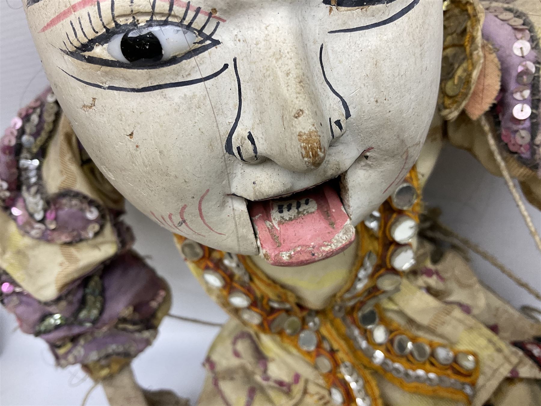 Large string puppet, probably Thai or Burmese, modelled as a woman in traditional costume embellished with sequins, the painted head with articulated mouth, the wood body and hands jointed, L70cm