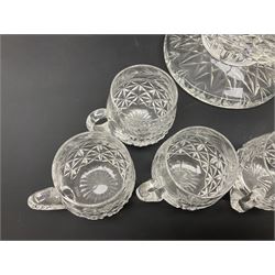 Large Stuart crystal pedestal punch bowl, of circular form, the rim with engraved floral decoration, upon spreading circular foot with radial cut decoration, with seven matching Stuart crystal drinking glasses, each with a C handle, each acid signed beneath, bowl H20cm