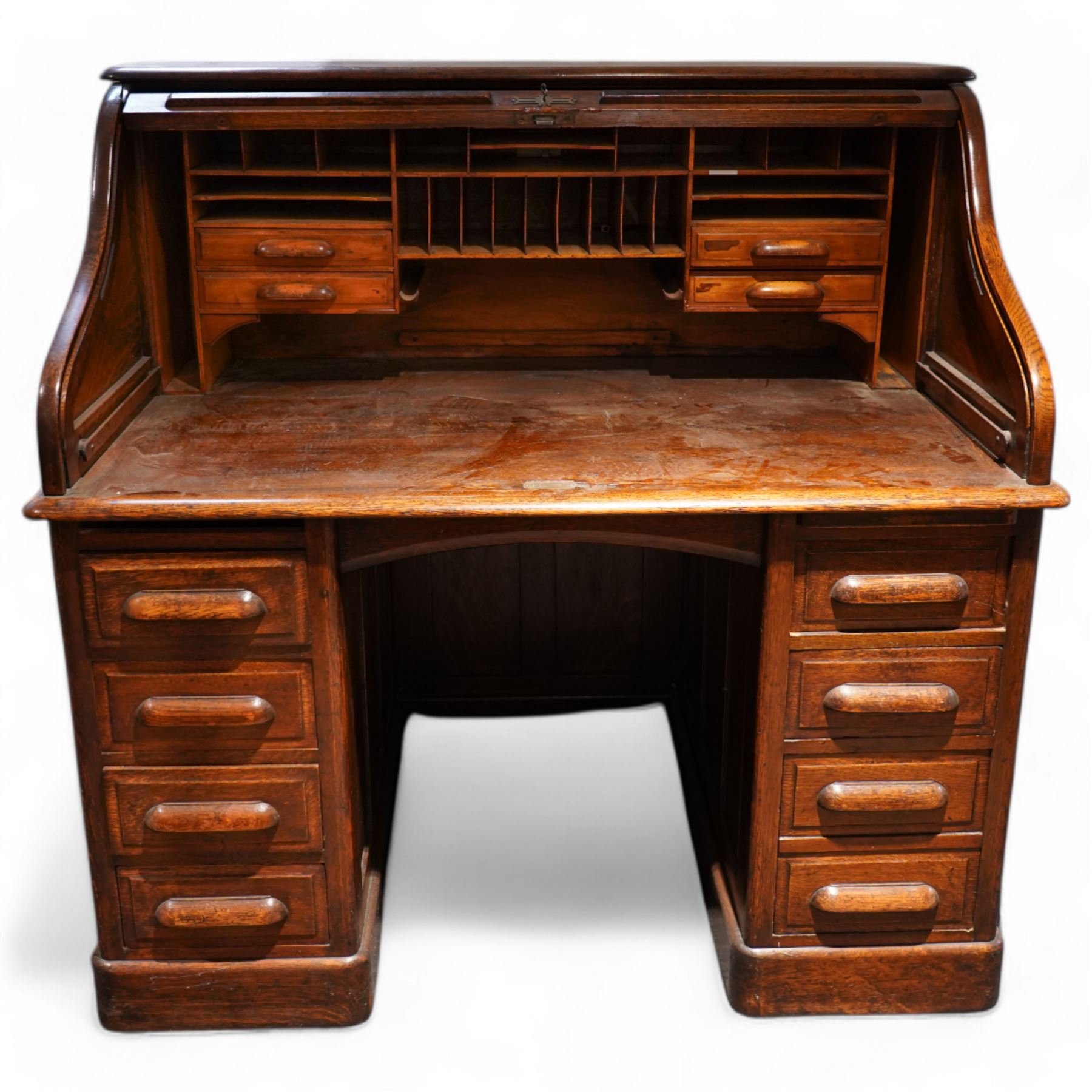 Early 20th century oak twin pedestal roll top desk, tambour roll enclosing small drawers and pigeon holes, fitted with seven drawers, on plinth base 