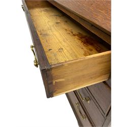 George III oak bureau, banded fall front enclosing fitted interior with central cupboard and reeded uprights, over four long graduating pine lined drawers with cock-beaded facias, on bracket feet