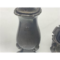 Modern two piece silver cruet set, comprising pepper shaker and open salt, each with shaped rims and upon four pad feet, hallmarked William Suckling Ltd, Birmingham 1962, together with an early 20th century silver open salt, of oval form, hallmarked William Aitken, Birmingham 1918