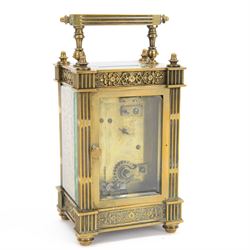 French - Matching pair of Edwardian 8-day timepiece carriage clocks with bevelled rectangular glass panels and overlaid friezes in gilt repousse work with fretted dial masks,  circular enamel chapter ring with Arabic numerals and steel spade hands, both clocks with single train movements, one movement with a jewelled cylinder platform escapement and the other with a jewelled and silvered lever platform escapement.
No Keys.