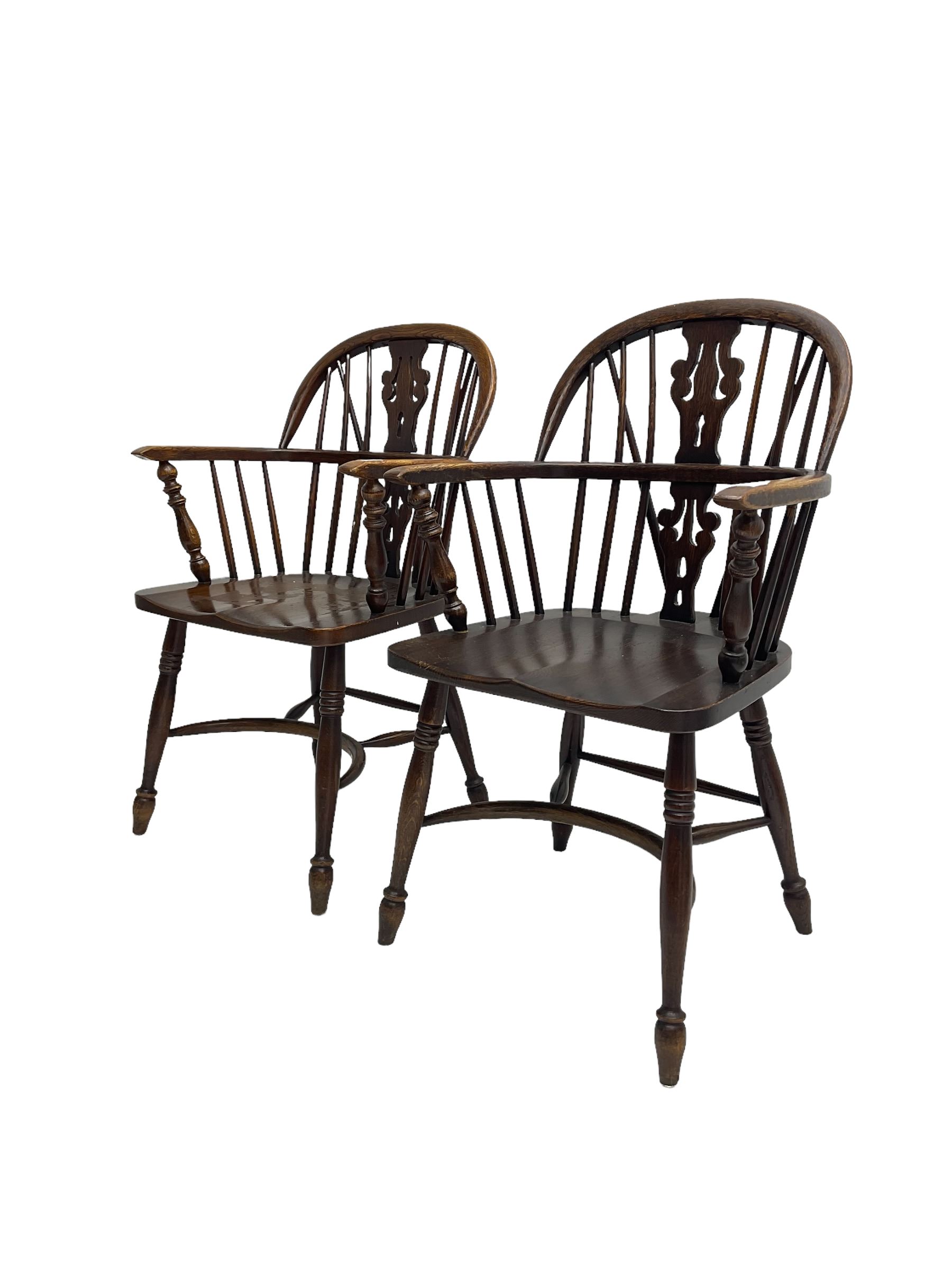 Pair late 20th century oak Windsor elbow chairs, double hoop and stick back with pierced and fretwork work splat, dished seat on turned supports joined by crinoline stretcher
