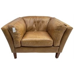 Contemporary mid-20th century shaped armchair with low back and sides upholstered in tan leather, raised on square tapering supports
