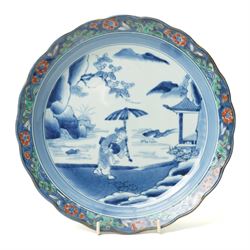 Japanese 19th century Arita style dish, painted centrally in blue and white with a lady ca...