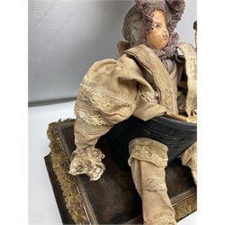 Modern reproduction automaton in the form of a baby doll in a basket clothed in Victorian style lace bloomers and frilled bonnet; clockwork action; on raised platform; with French paper label on base, 29cm wide,