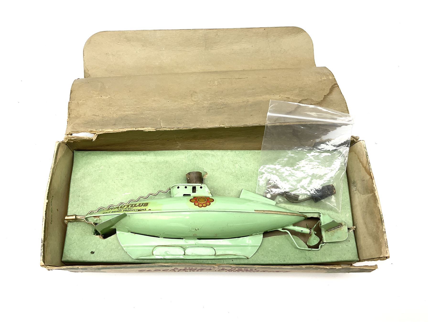 Sutcliffe Models ‘Nautilus’ tinplate and clockwork submarine from Walt Disney’s ’20,000 Leagues Under The Sea’ by Jules Verne, sea green body with various decals, rubber bung with periscope, boxed with inner cardboard display piece, produced between 1955-1960