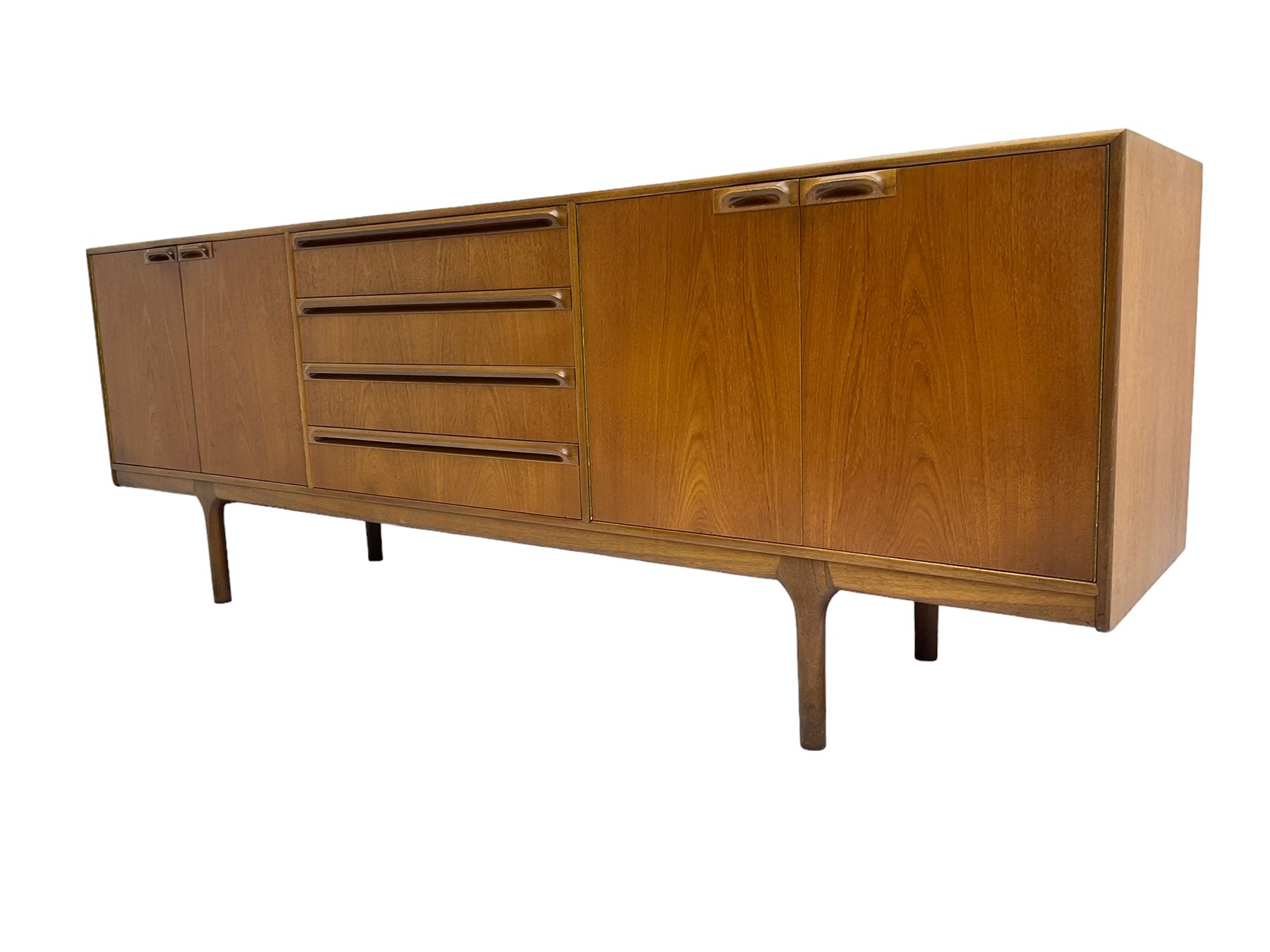 Tom Robertson for AH McIntosh & Co of Kirkaldy - mid-20th century teak sideboard, fitted with four central drawers, flanked by cupboard enclosing shelves and sliding tray, raised on cylindrical supports