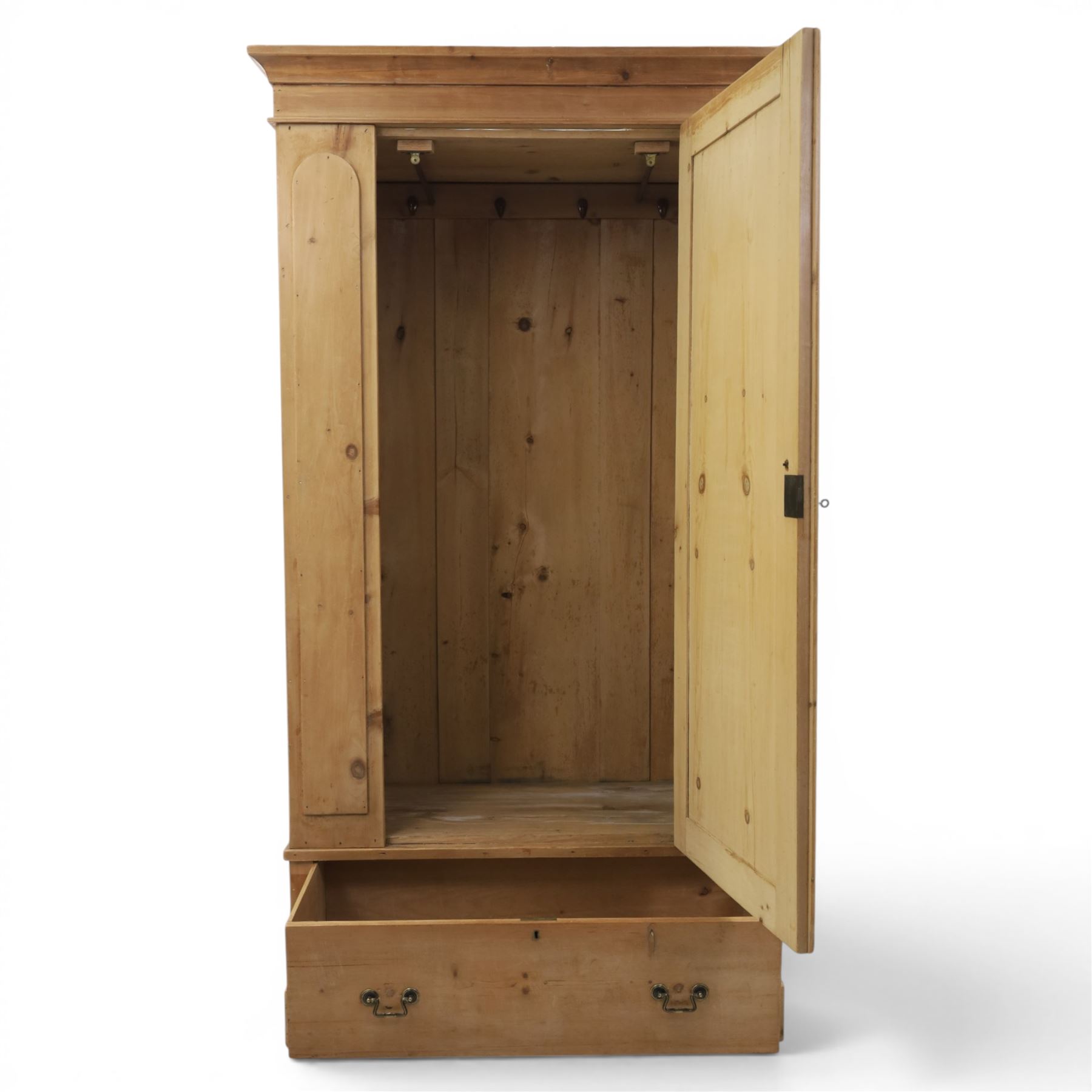 Traditional waxed pine single wardrobe, featuring single panelled door above base drawer, loop handles
