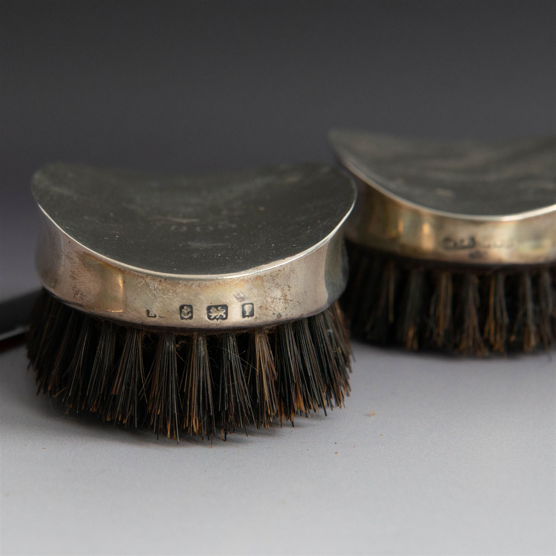 Edwardian tortoiseshell page turner with silver handle, hallmarked Birmingham 1906, maker's mark worn and indistinct, together with a pair of Edwardian silver mounted horsehair brushes engraved with monogram, and two faceted glass jars with silver lids and applied initial N to covers, all hallmarked 