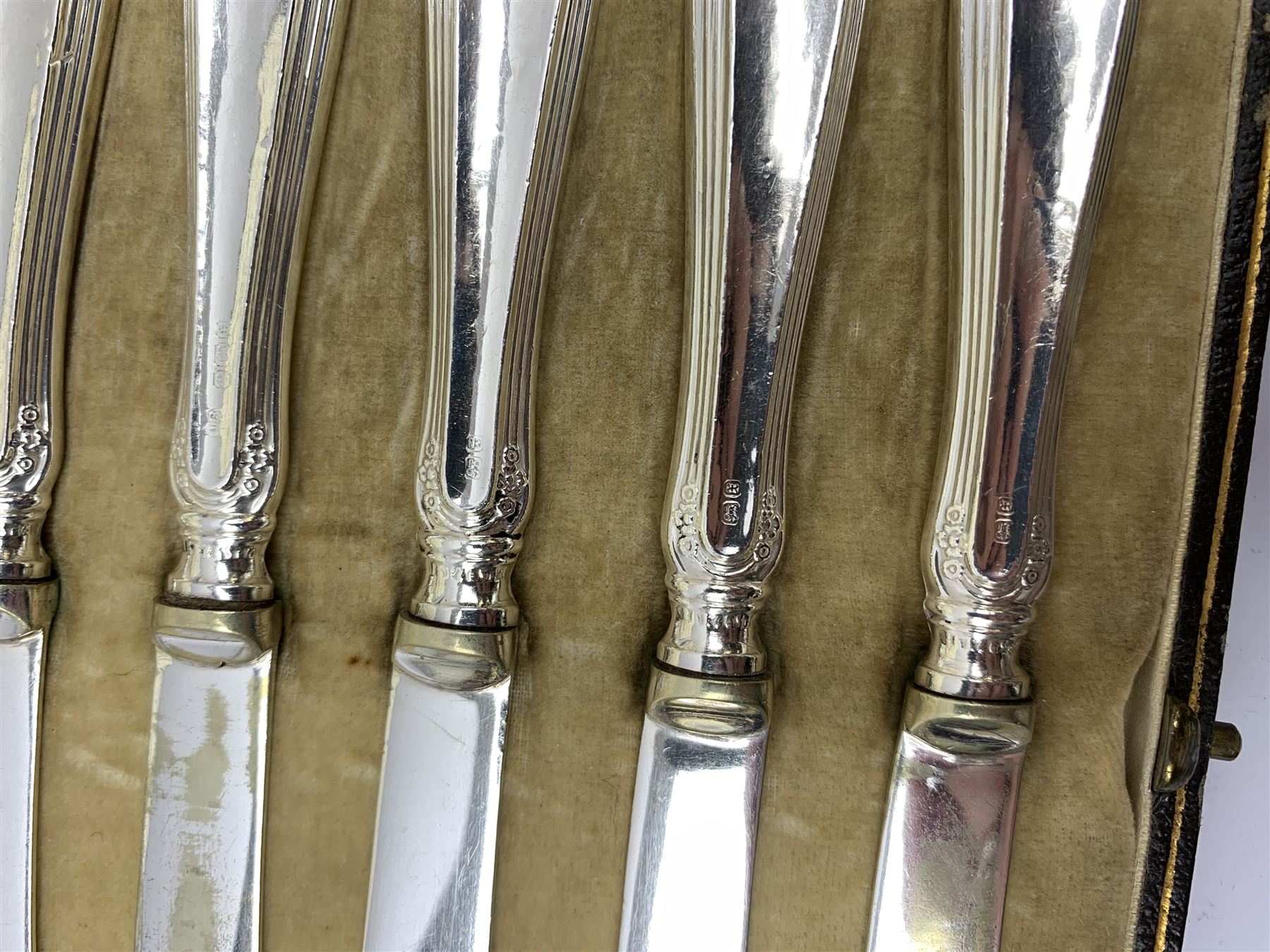 Two silver napkin rings by Collingwood & Sons Ltd, Birmingham 1928 and two other silver napkin rings hallmarked, approx 3.2oz, cased set of silver silver handled knives, hallmarked Sheffield 1915, together with a selection of silver plated flatware, to include Walker and Hall fish eaters set, cased nut cracker set with grape scissors, etc., plus a silver mounted hair brush and hand held mirror, hallmarked Chester 1919