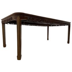 Late 20th century Chinese carved hardwood extending dining table, rectangular panelled top with rounded corners over a pierced frieze carved with dragon motifs and scrolling foliate decoration, with two additional leaves