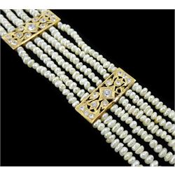 18ct gold pearl and white paste stone bracelet, six strands of cultured white pearls, spaced by openwork gold panels set with paste stones