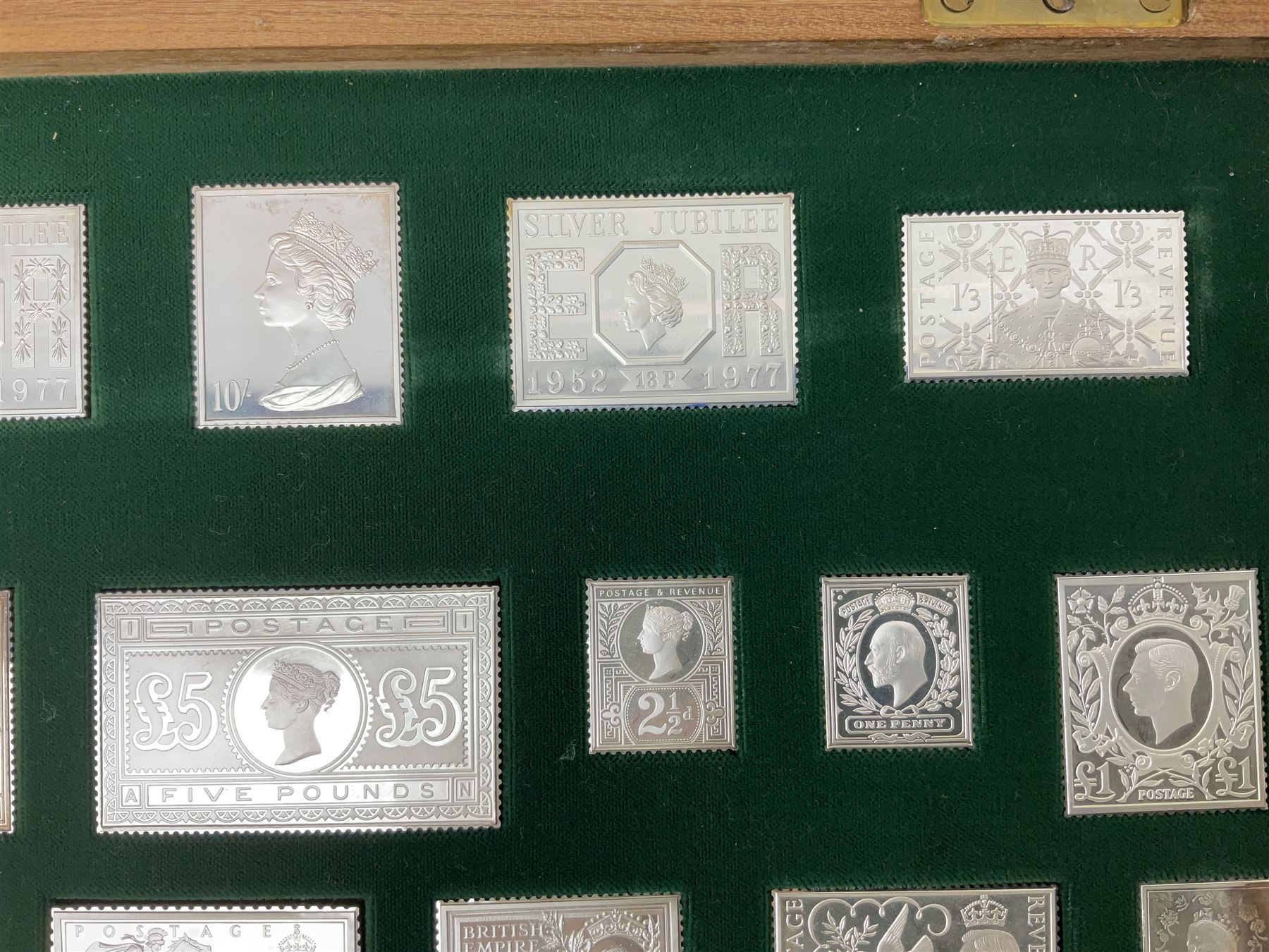 The Stamps of Royalty collection consisting of twenty-five sterling silver hallmarked stamp replicas, housed in a fitted wooden display case, with certificates, polishing cloth and certificates