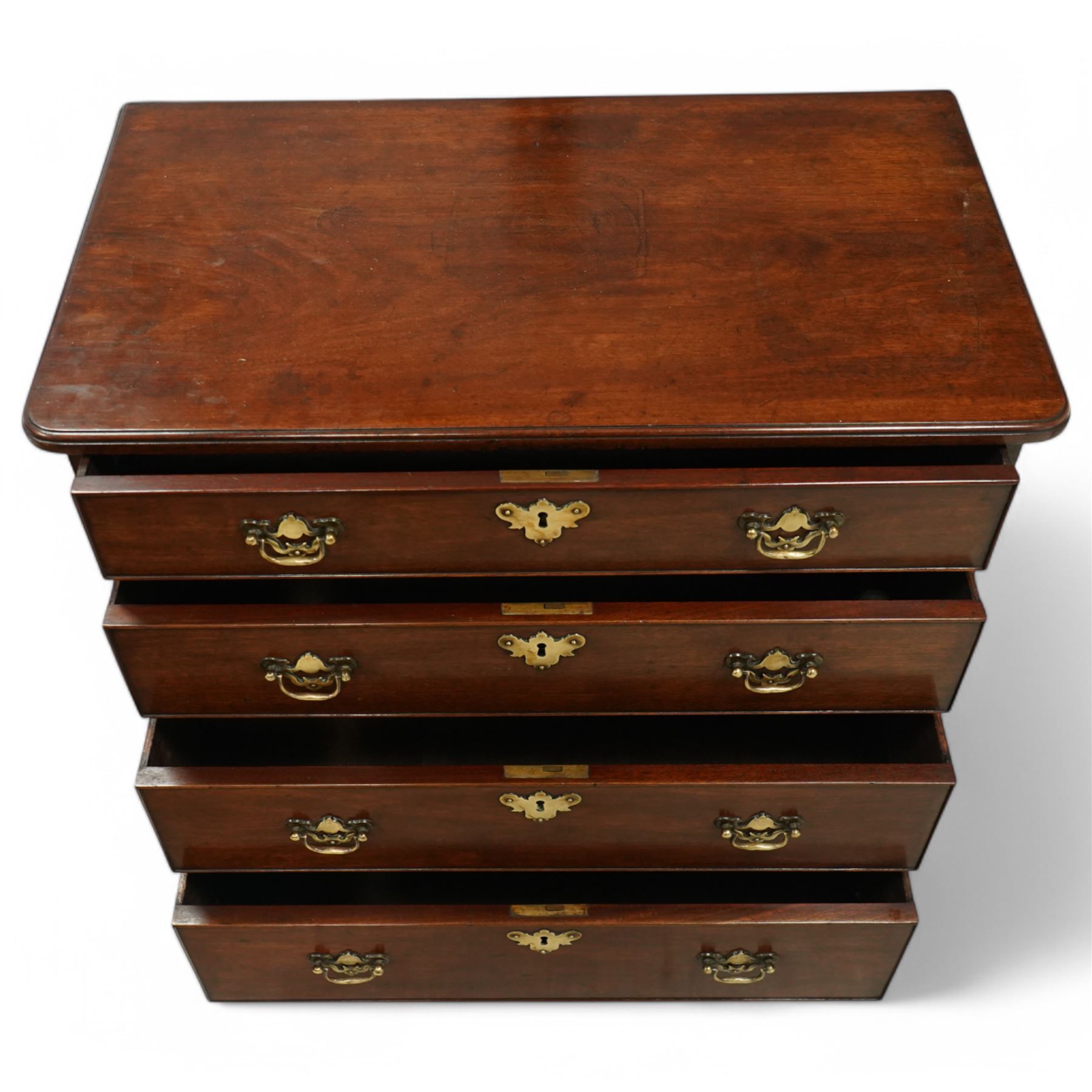 Small Georgian mahogany chest of drawers with four long graduated drawers with swan neck handles on ogee feet