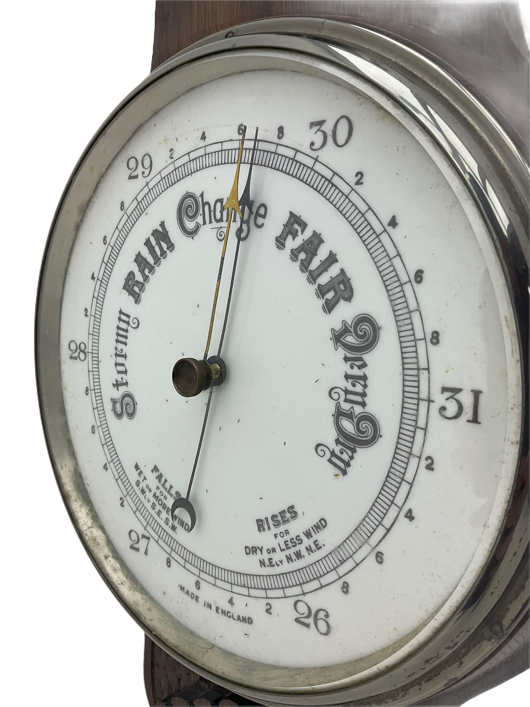 An English carved oak cased aneroid barometer with an 8'' porcelain