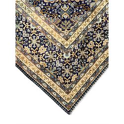 Persian indigo and pale gold ground rug, overall busy geometric design, the field decorated with hooked Hac and palmette medallions surrounded by densely patterned zig-zags and stylised foliate motifs, the border decorated with smaller Hac motifs, within multiple guard stripes 