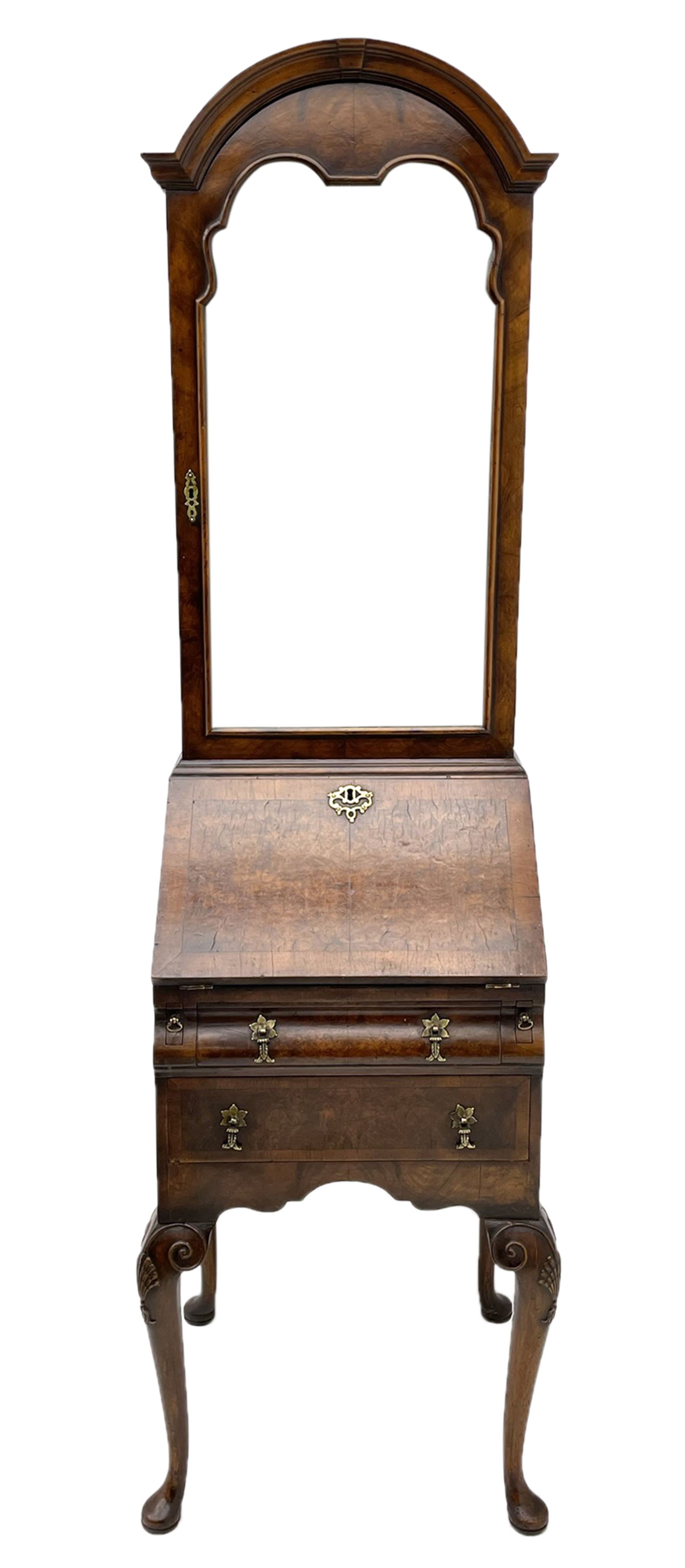 Small early 20th century Queen Anne style bookcase on bureau secretaire, the moulded arched pediment over mirrored door in shaped frame, the bureau fitted with fall front enclosing curved fitted interior, cushion moulded drawer over single drawer, on scroll and shell carved cabriole supports