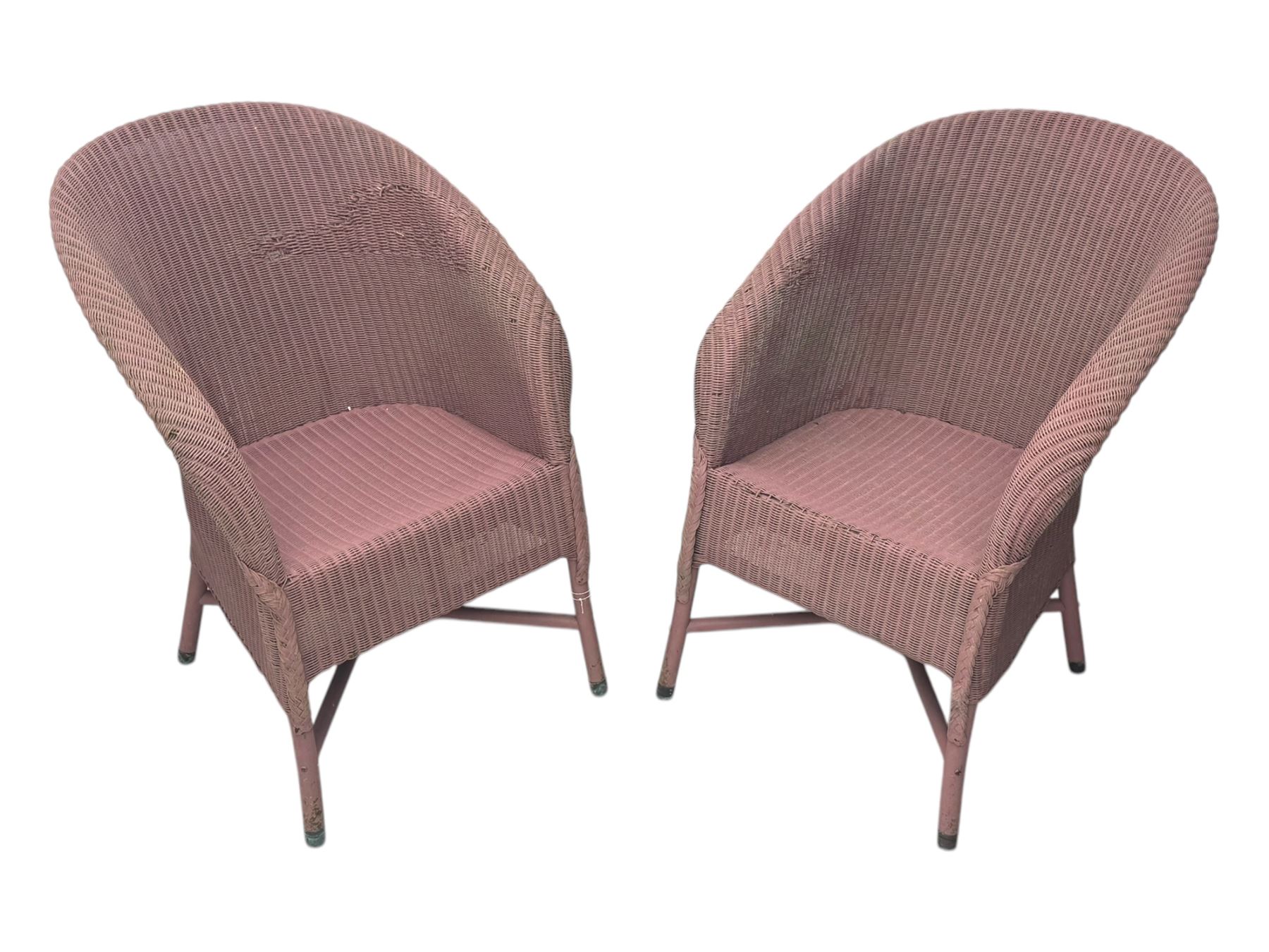 Pair of Lloyd Loom design tub chairs, each with woven wicker construction, curved backrests and painted in a soft pink finish, on cylindrical supports with X-stretchers