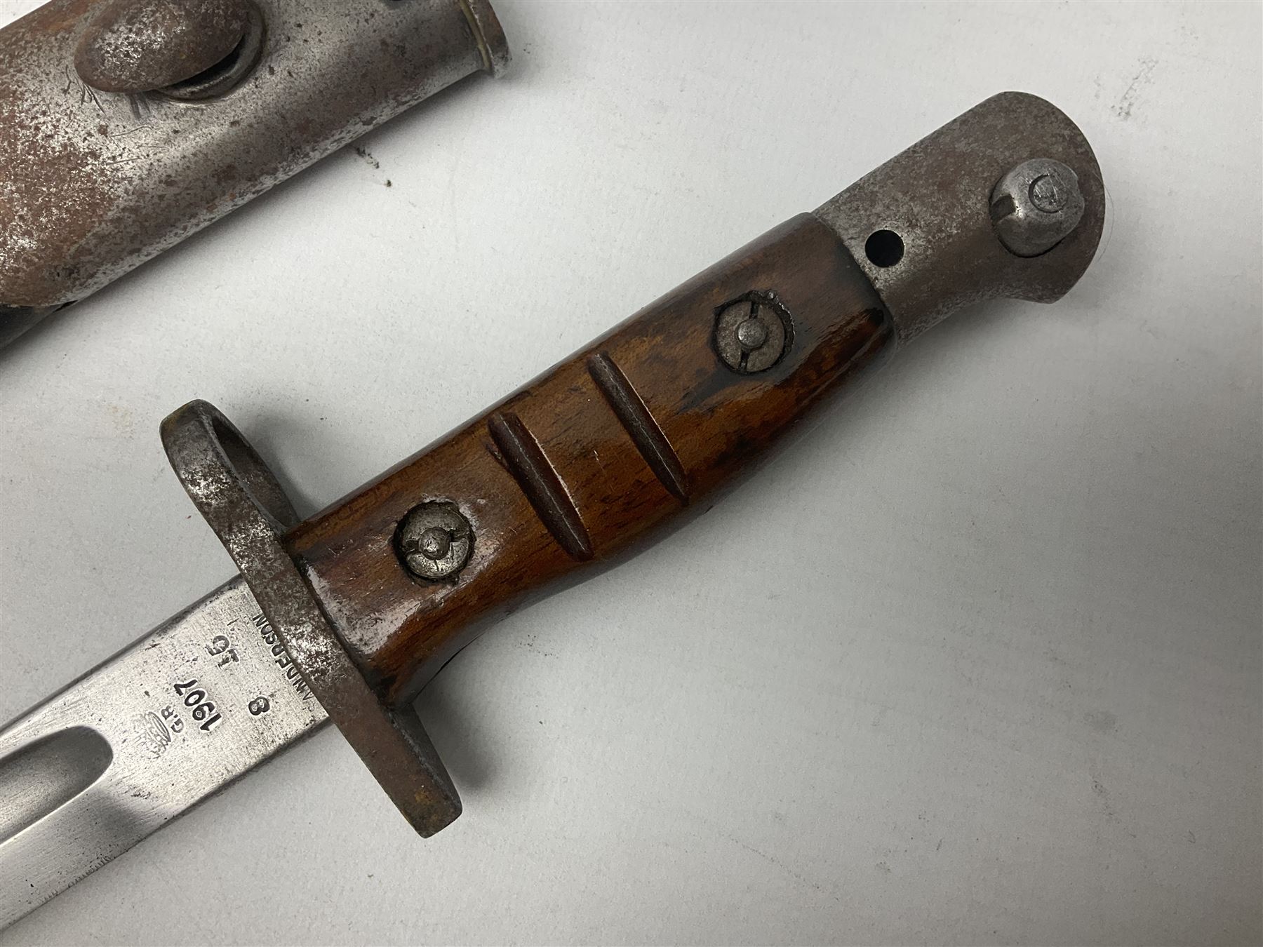 WW1 British 1907 pattern bayonet, the 43cm single edged fullered blade stamped to the ricasso with a crown GR cypher 1907 8 15 Sanderson, with various ordnance marks verso, two piece walnut grip, pommel stamped 1HLI 354; in steel mounted leather scabbard stamped 140 to the throat L57cm overall