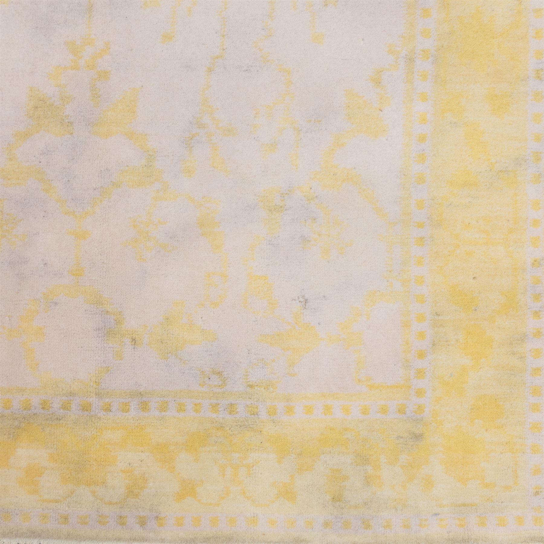 Tibetan wool rug, decorated with a pale cream ground and yellow all-over foliate design, enclosed by a broad yellow floral border and narrow inner guard band