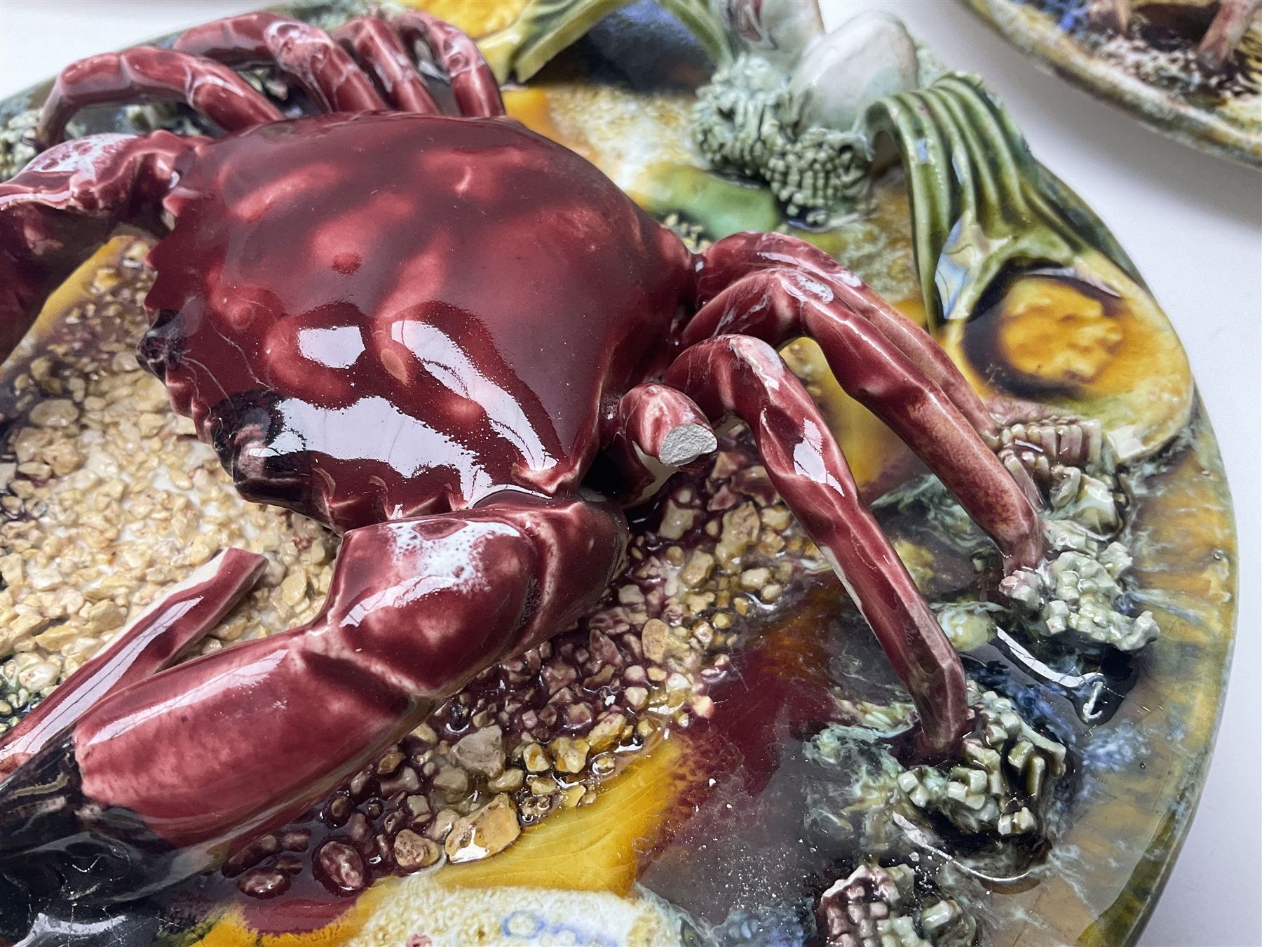 Five 20th Century Portuguese Palissy style Majolica wall plates, all depicting crustaceans to the centre modelled in relief surrounded by encrustations and shells, both with impress marks beneath, largest D29cm