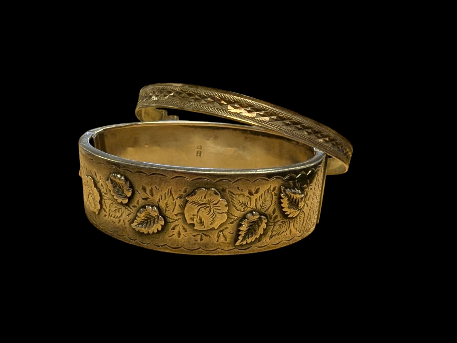Two silver bangles, including one example with relief floral decoration, hallmarked 