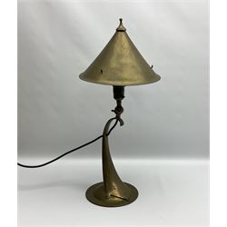 Arts & Crafts Jesson, Birkett & Co, brass table lamp or wall light, designed by Thomas Birkett, the tapering stem with adjustable ball pivot supporting a conical shade with tapering final with ball terminal, upon a circular domed base pierced for wall mounting, shade positioned upright overall H57cm

Often misattributed to Arthur Stansfield Dixon for Birmingham Guild of Handicraft, this particular lamp was designed by Thomas Birkett.
In the late 1890's Birkett worked as a metalwork at the Birmingham Guild, before later joining the Faulkner Bronze Company which went on to become Jesson, Birkett & Co in 1904. The lamp features in lighting catalogues from the firm under the model no E490.

