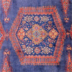 Central Persian Veis hand-knotted carpet, deep blue indigo field with central stepped lozenge medallion filled with stylized floral and geometric motifs, flanked by further angular medallions and tribal devices, edges with articulated and serrated hooked forms within a wide geometric border with repeating stylized floral motifs and multiple guard borders, in madder red, indigo blue, ivory, olive green, with cotton fringe ends