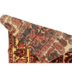 Two Persian crimson ground rugs, decorated with floral and foliate motifs max 137cm x 82cm (2)