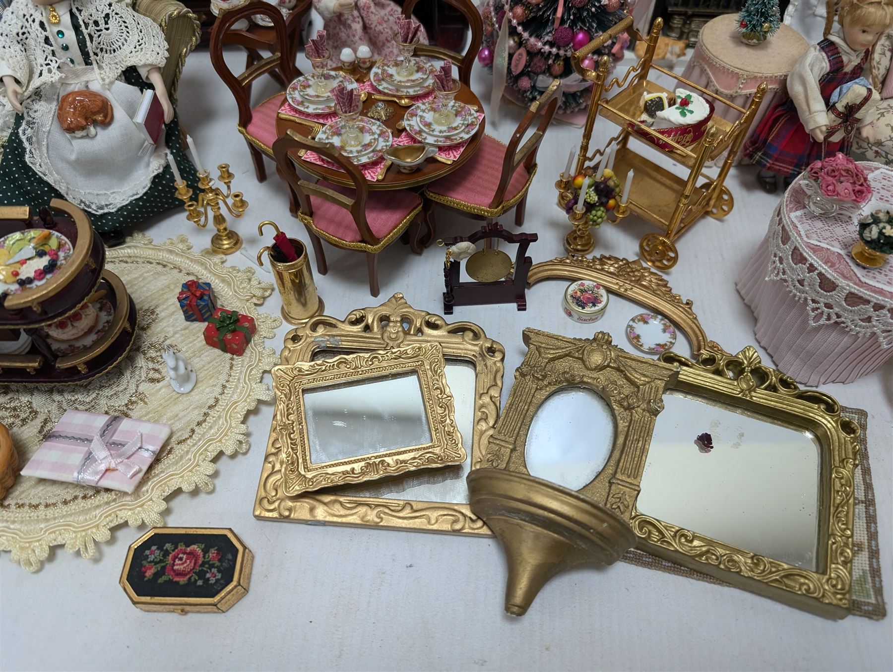 Dolls house living room and ding room furniture, including sofa, chair, long case clock, Christmas trees, fireplace, dresser, chairs, tables, mirrors, seven figures and a collection of predominantly Christmas themed decorations, food, etc