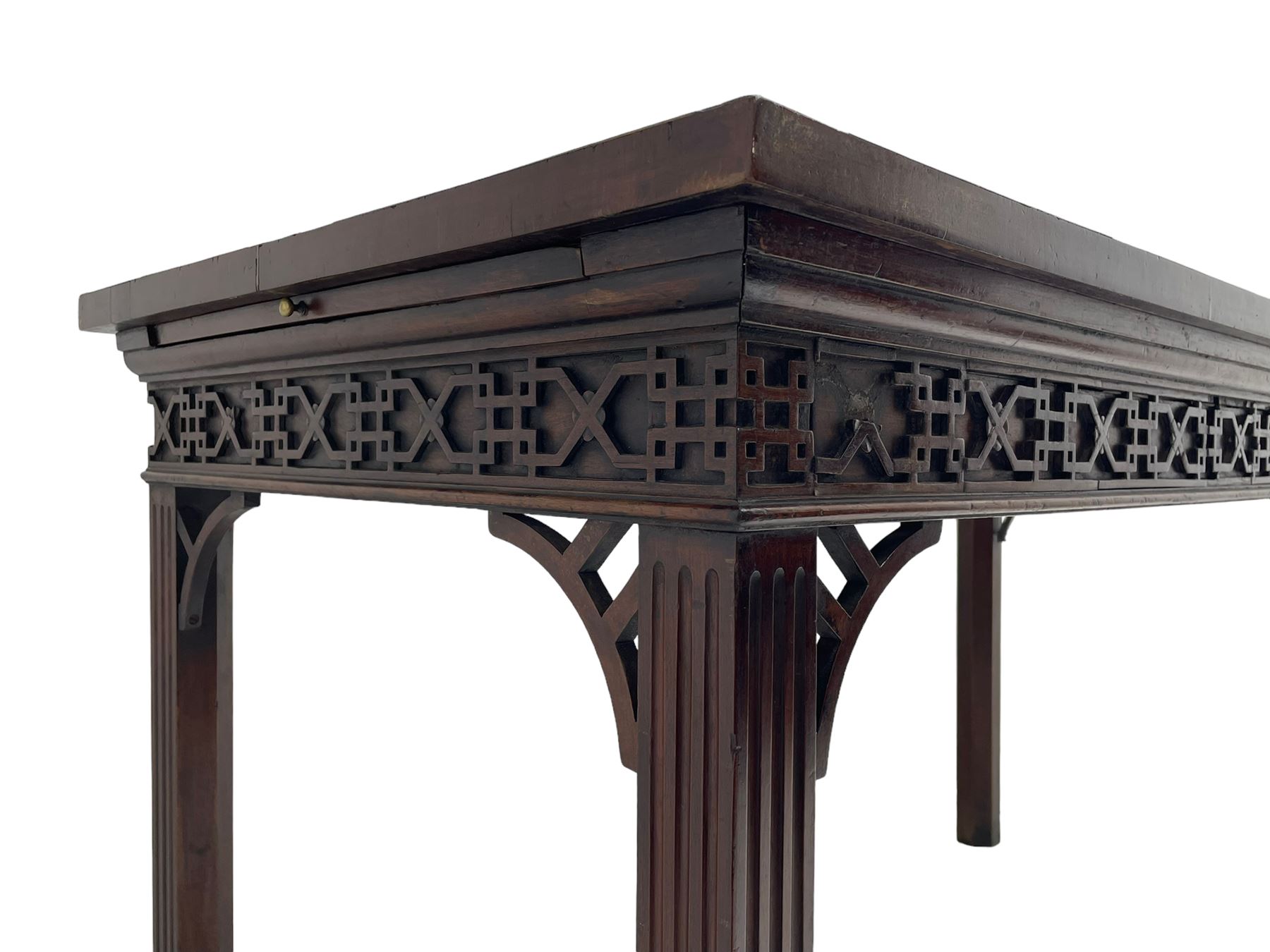 In the manner of Thomas Chippendale - early 19th century mahogany serving table, rectangular crossbanded top with boxwood stringing, the frieze with upper moulding over applied geometric fretwork, the left-hand side fitted with slide, on fluted square supports with inner chamfer 