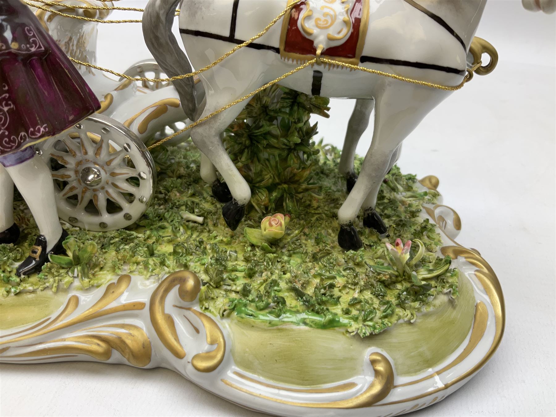 Capodimonte figure group of a horse drawn carriage with two horses pulling an open carriage with a male with dresden lace cuff and a female with full dresden lace skirt,  on a naturalistic base, H15.5cm