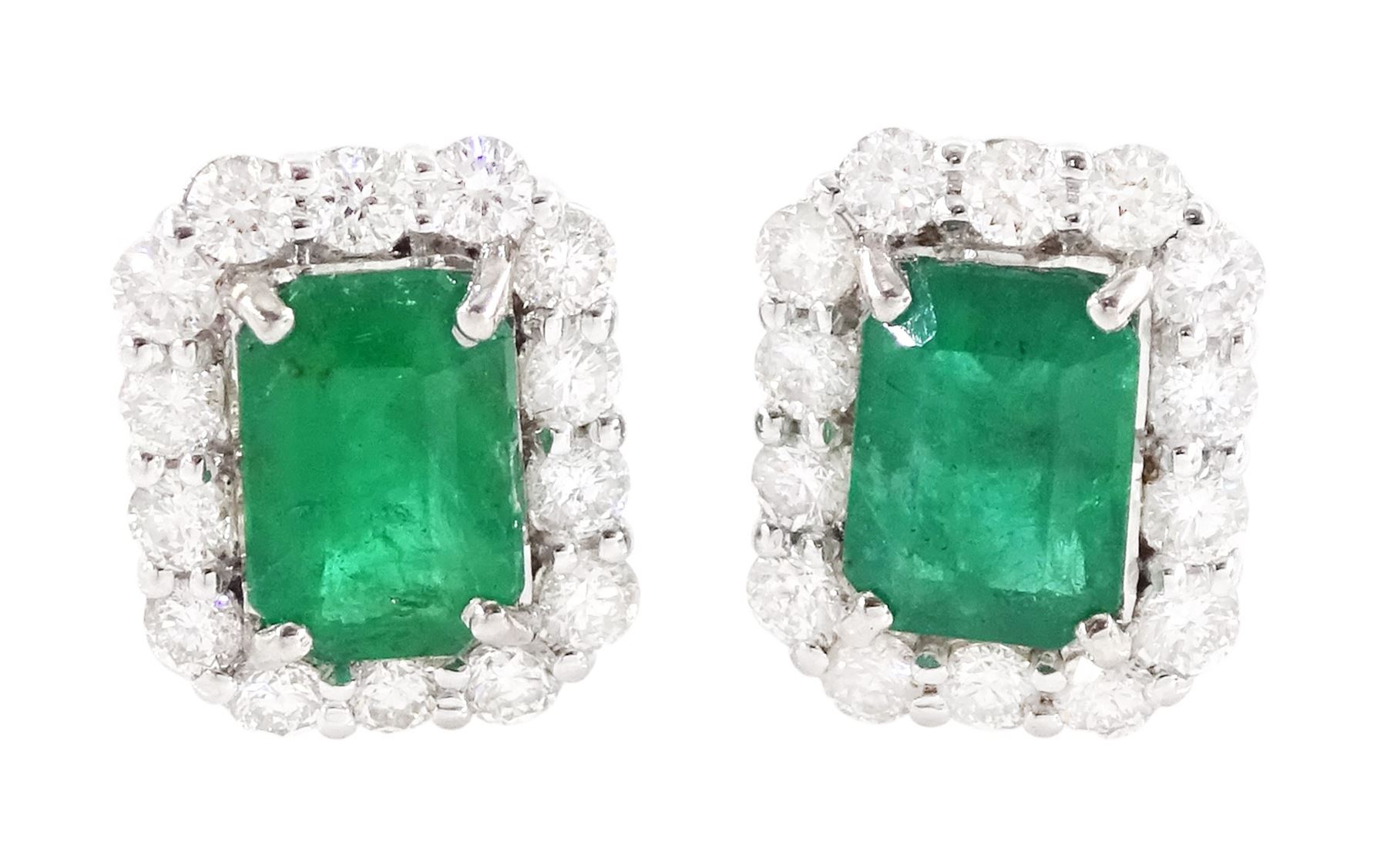 Pair of 18ct white gold emerald and diamond cluster earrings, each stud set with a single octagonal cut emerald, with round brilliant cut diamond surround, stamped, total emerald weight approx 1.30 carat, total diamond weight approx 0.70 carat