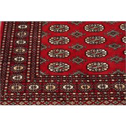 Two Afghan Bokhara crimson ground rugs, the fields decorated with repeating Gul motifs with geometric guard bands (126x190 & 157x250)