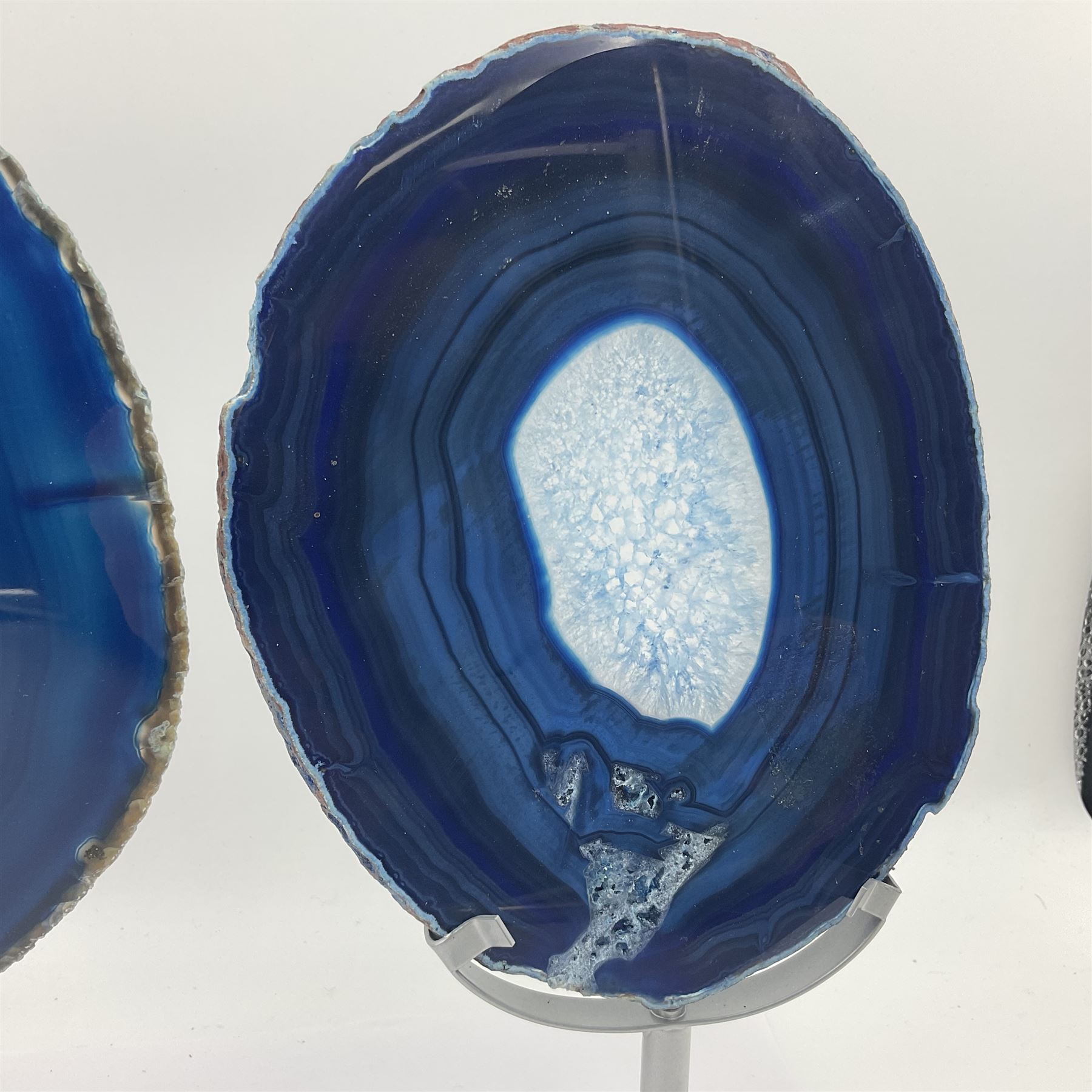 Pair of blue agate slices, polished with rough edges, raised upon silvered metal stands, H26cm