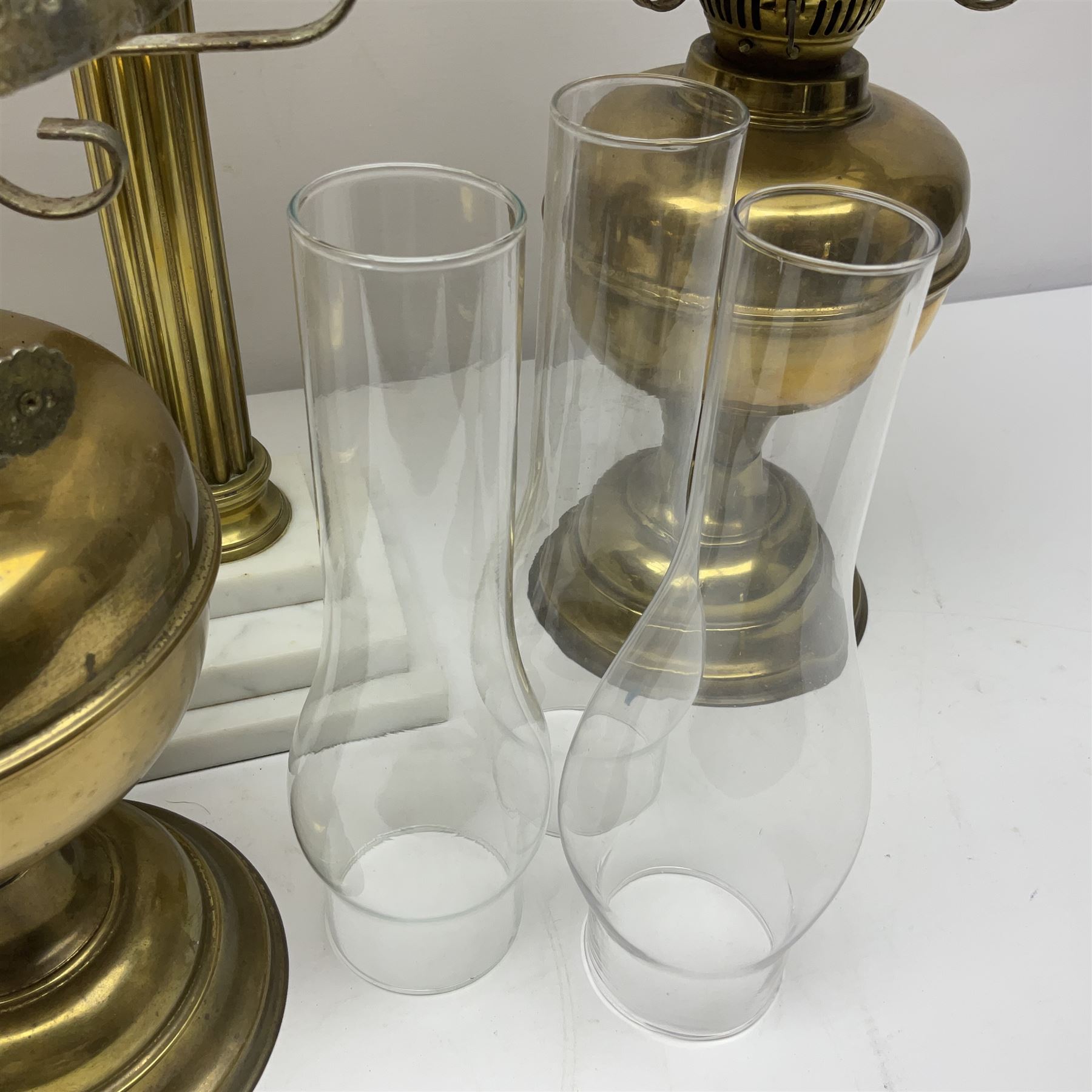 Brass Corinthian column oil lamp, upon stepped marble base, together three other brass table lamps, tallest H68cm